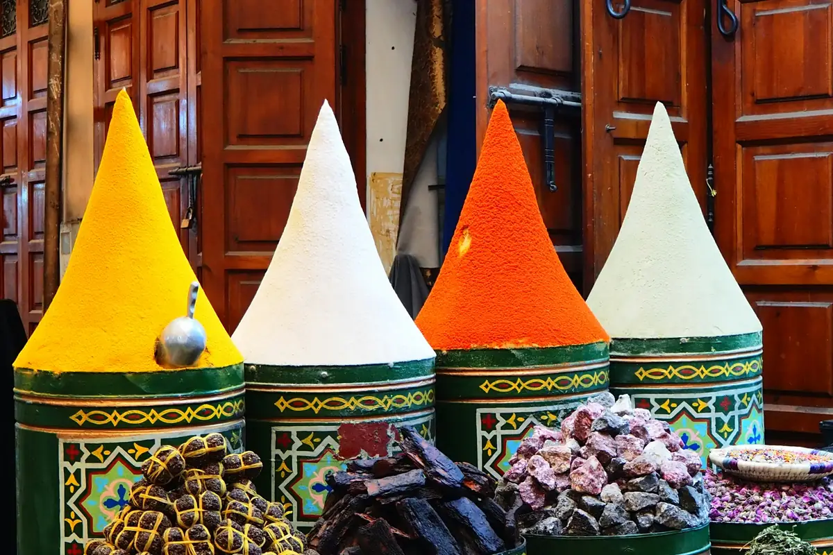 Cones of spice stacked on painted drums at a market stall