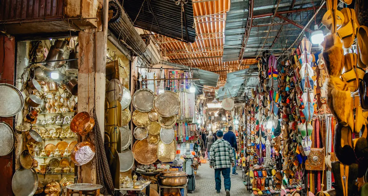 A covered souk alley hung with lamps and baskets