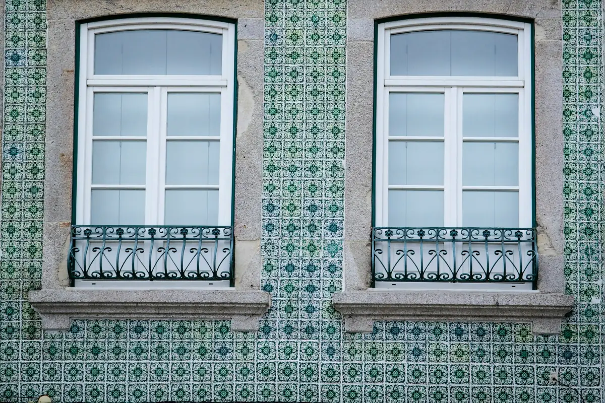 Two windows set into a green-and-white tiled façade