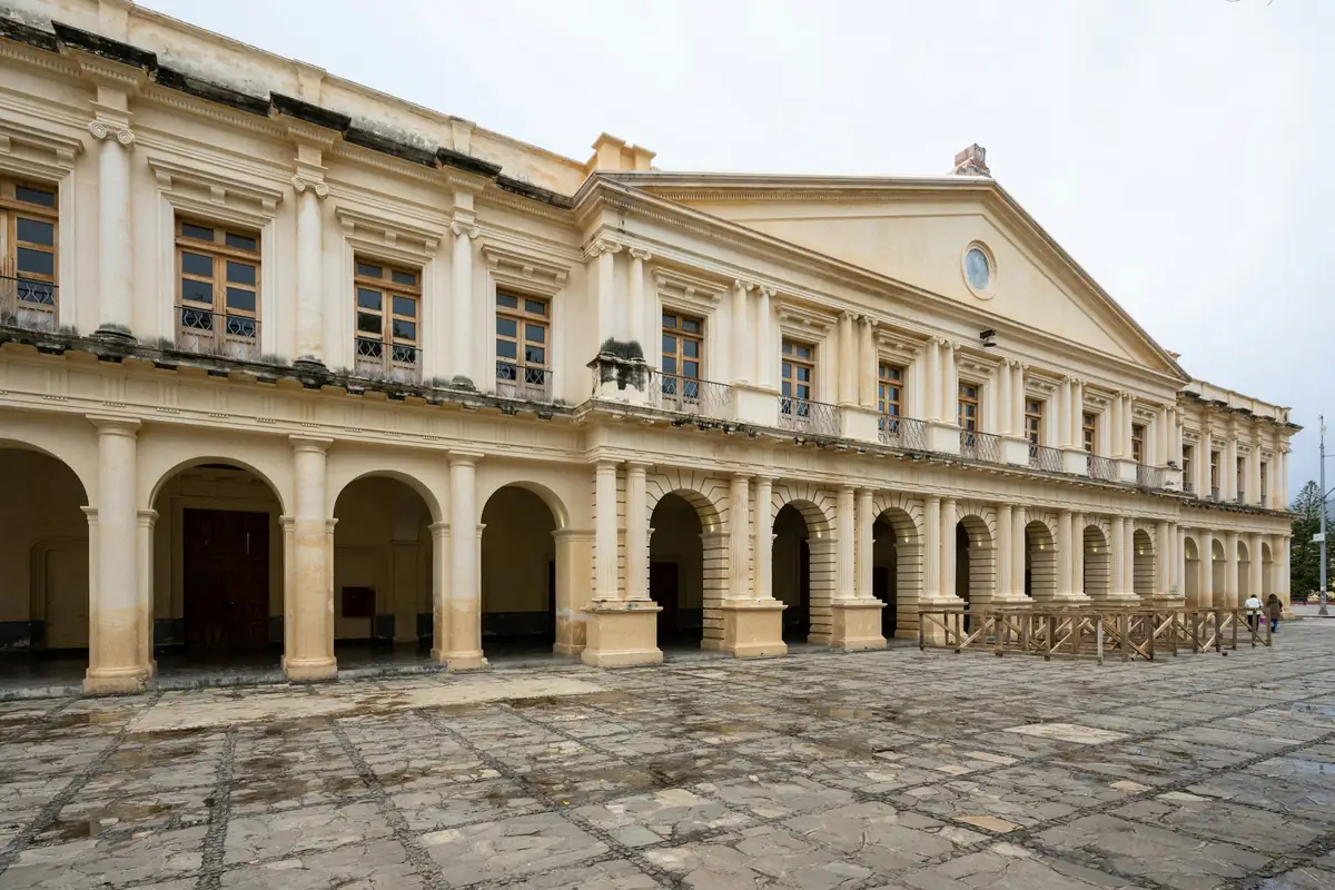 A long stone arcade of arches along a quiet plaza