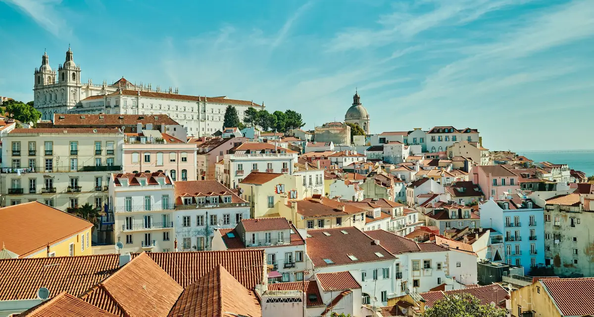 Tiled rooftops and a church dome above the river