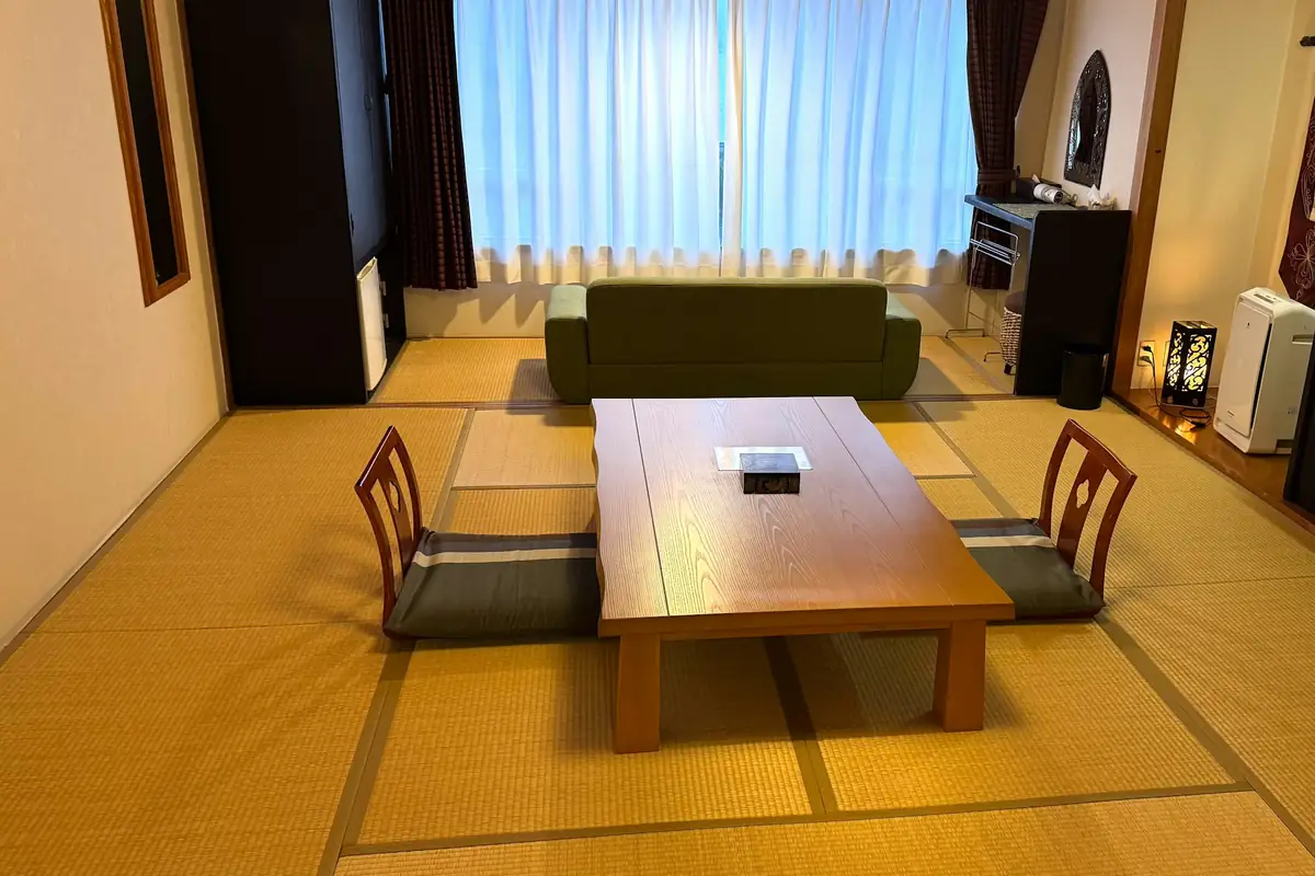 A tatami room with a low table and floor chairs