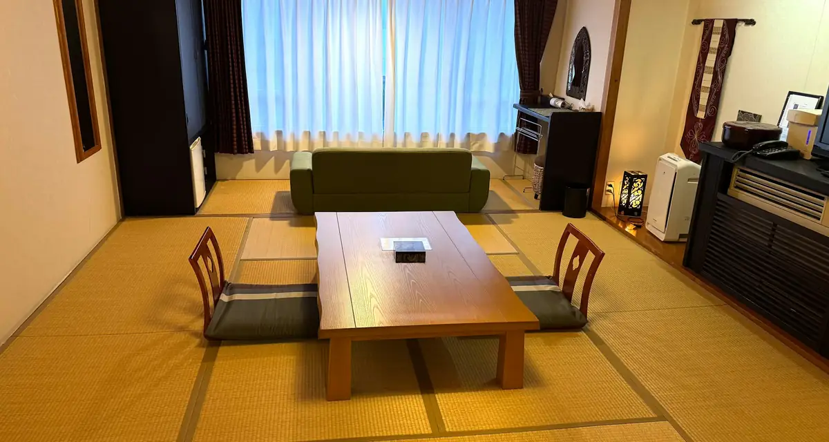 A tatami room with a low table and floor chairs