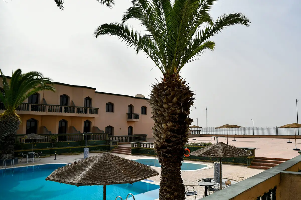The pool and the palm trees behind the annex